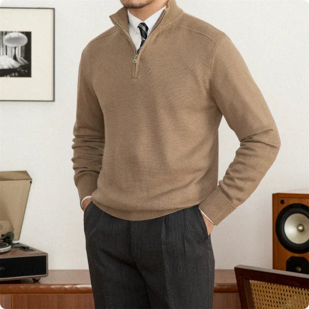 Man wearing a brown sweater and dark pants in a room with vintage decor.