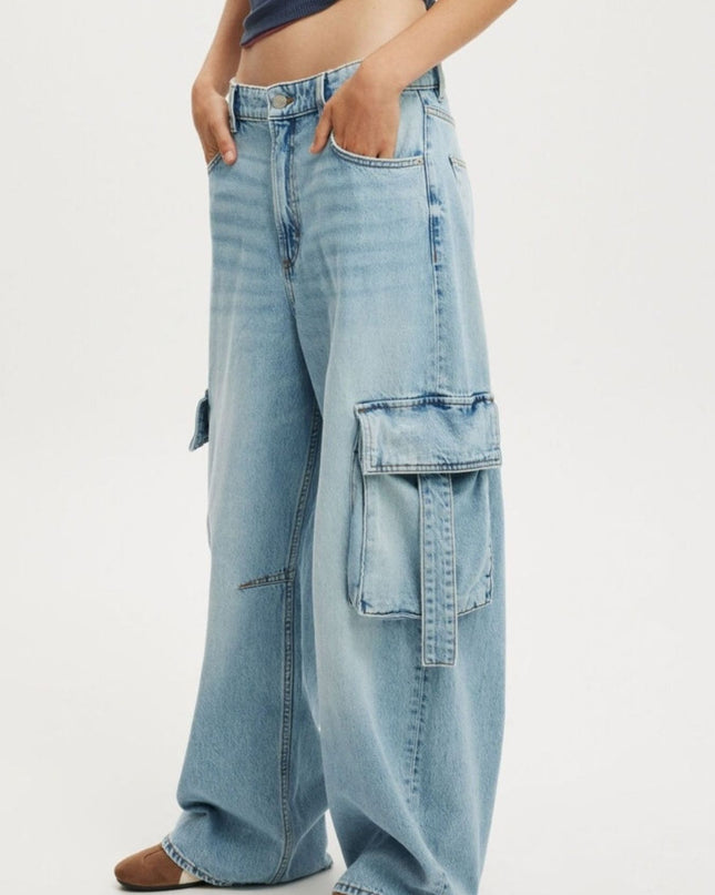 Light blue denim cargo pants worn by a person on a white background