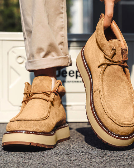 Tan suede shoes worn by a person on a blurred background