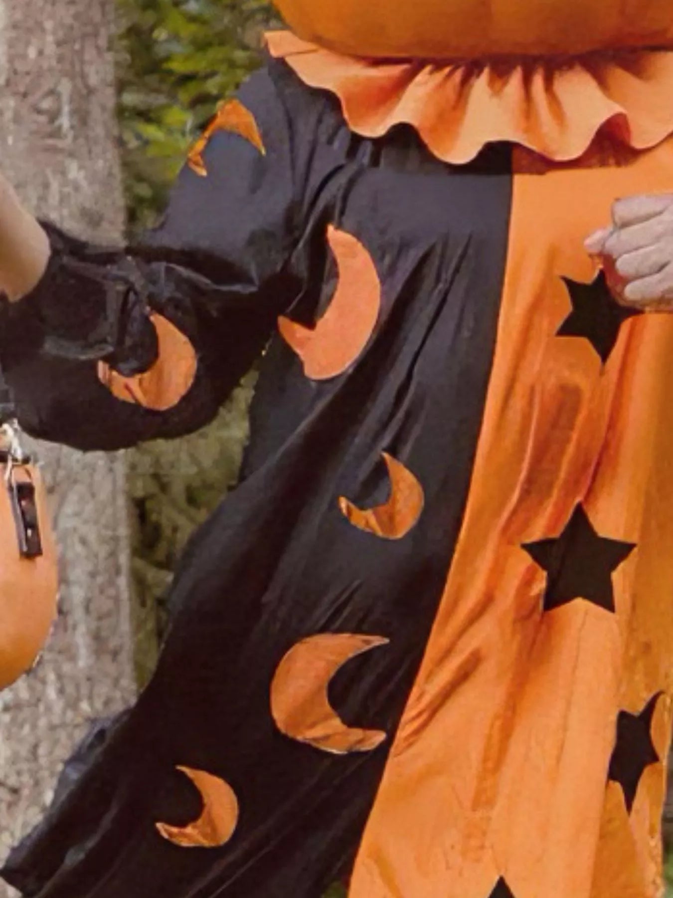 Person wearing a Halloween-themed outfit with black and orange patterns.