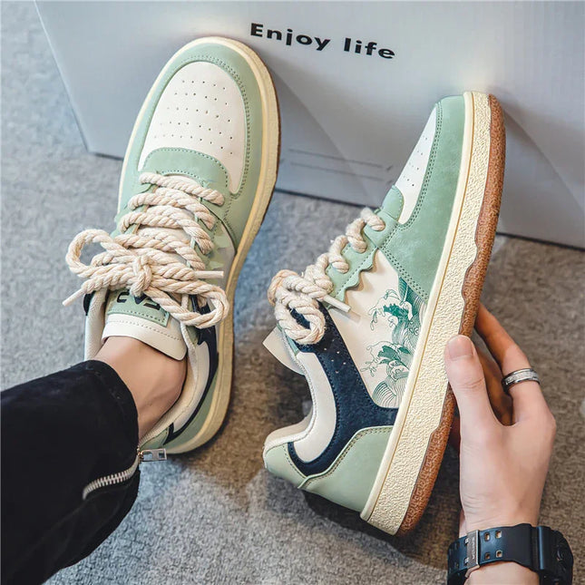 Pair of green and white sneakers with brown soles, held by a hand, on a light gray surface with 'Enjoy life' text in the background.