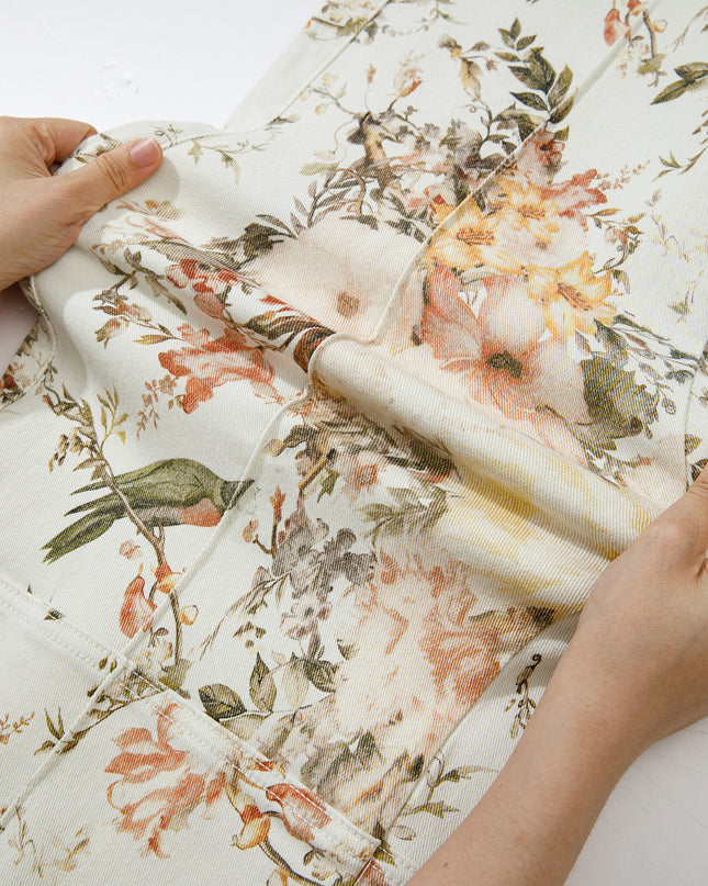 Floral fabric being held by hands on a white background