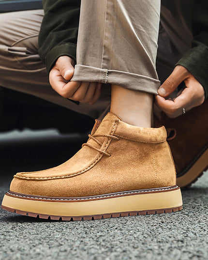 Person wearing a tan suede boot with a blurred background