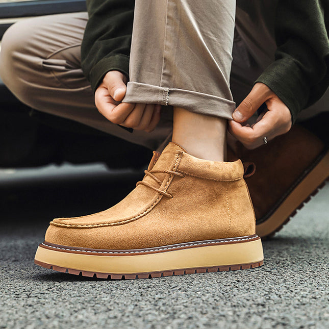 Person wearing a tan suede boot with a blurred background