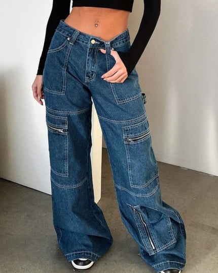 Person wearing wide-leg blue jeans with zippers on a plain background