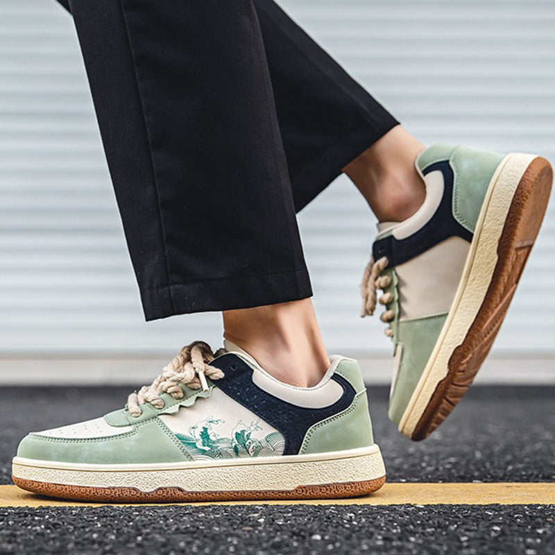 Person wearing green and navy sneakers with a brown sole on a blurred background