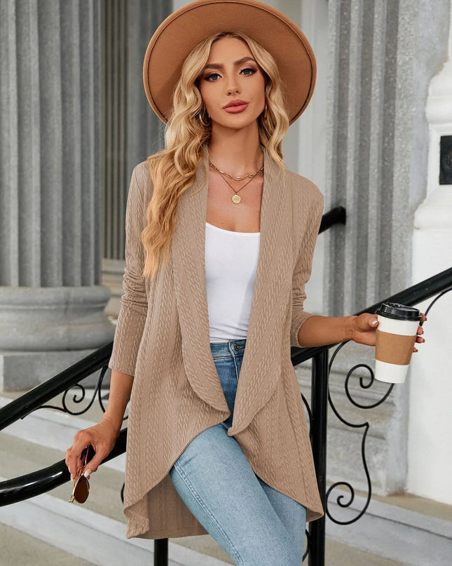 Woman in beige cardigan and hat holding a coffee cup outdoors.