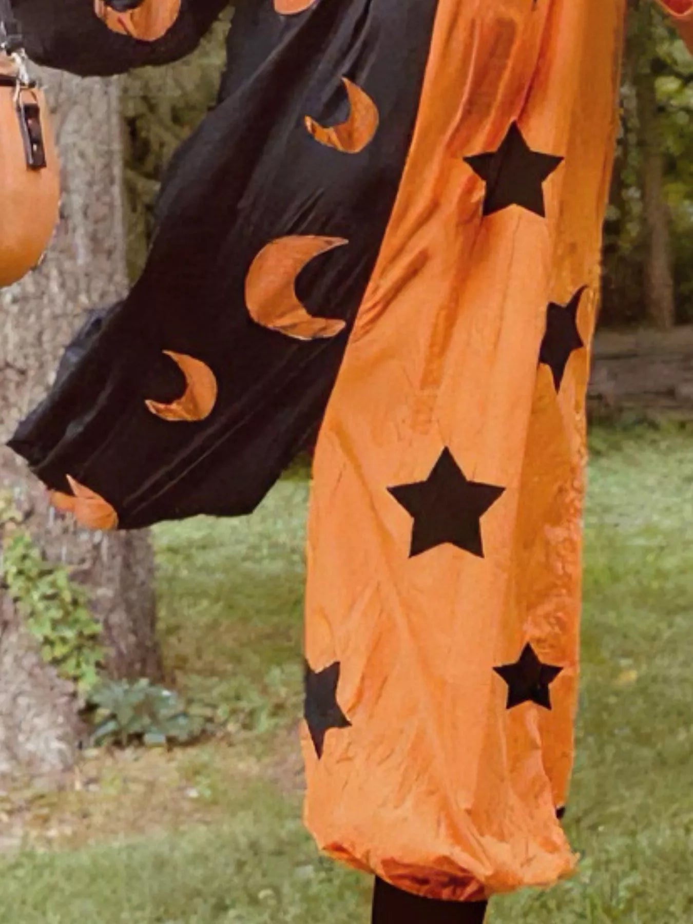 Halloween-themed skirt with black stars and orange moons on a person outdoors.