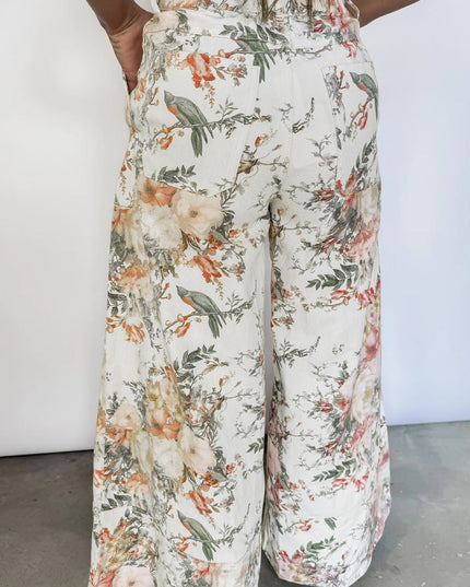 Floral patterned pants worn by a person on a plain background