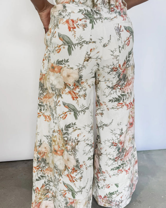 Floral patterned pants worn by a person on a plain background