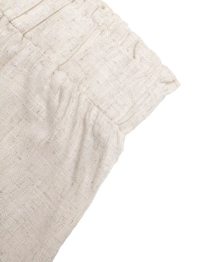 Close-up of beige fabric with a textured pattern on a white background