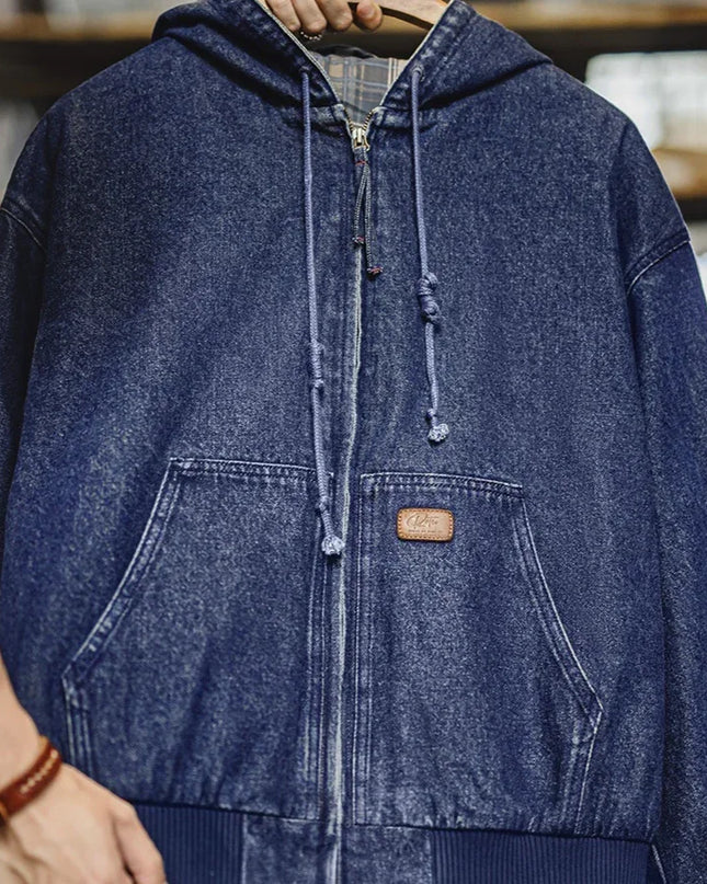 Blue denim jacket with a brand logo on a hanger against a blurred bookshelf background