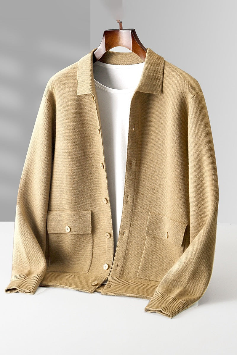 Beige cardigan on a hanger against a gray background