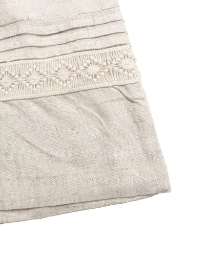 Close-up of a light gray dress with lace detailing on a white background