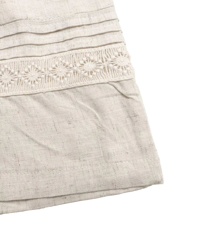 Close-up of a light gray dress with lace detailing on a white background