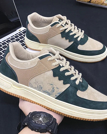 Pair of green and beige sneakers with a laptop in the background