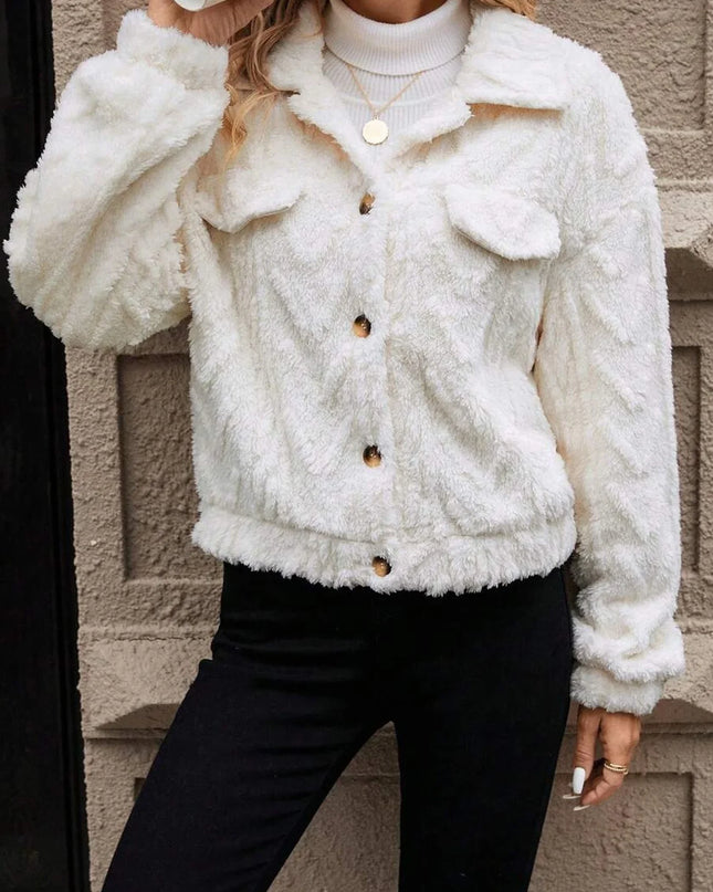 Person wearing a white fluffy jacket against a neutral wall.