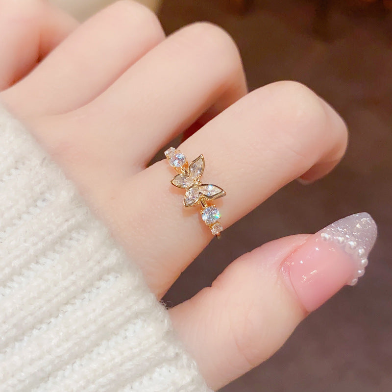 Gold butterfly ring on a finger with a blurred background