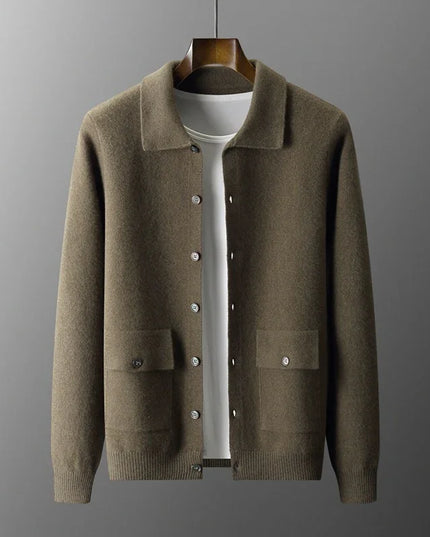 Brown knitted cardigan on a wooden hanger against a gray background