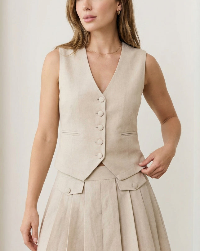 Woman wearing a beige vest and skirt set on a plain background