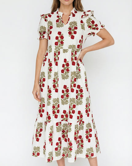Woman wearing a white dress with red floral pattern on a white background