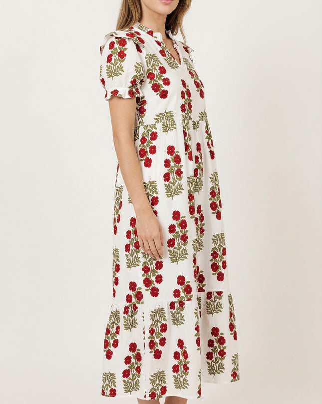 Woman wearing a white dress with red floral pattern on a white background