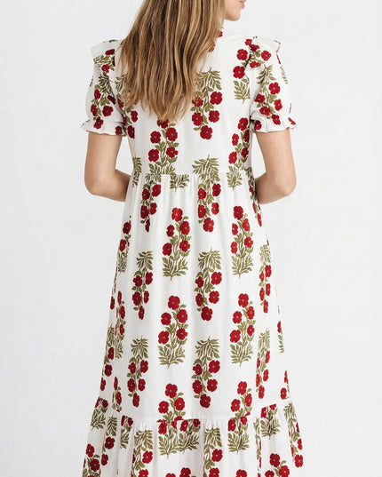 Woman wearing a white dress with red floral pattern on a white background