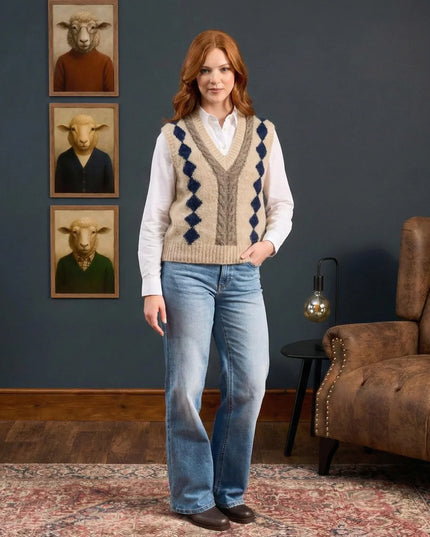 Woman wearing a patterned vest and jeans standing in a room with a brown armchair and wall art.