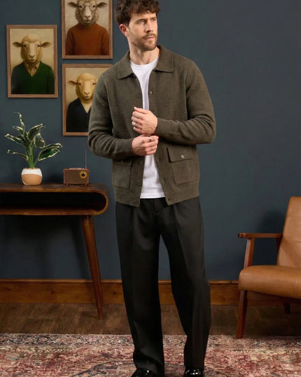 Man standing in a room with framed pictures of animals on the wall.