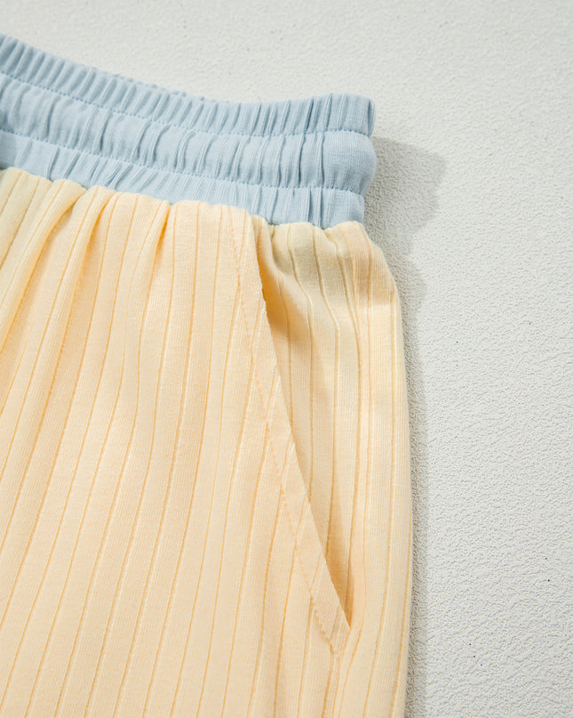 Light blue top and yellow pleated skirt on a light gray background