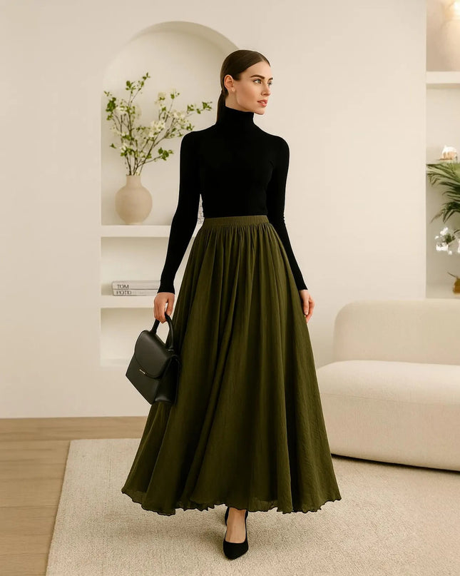 Woman in a black turtleneck and green skirt standing in a modern living room.