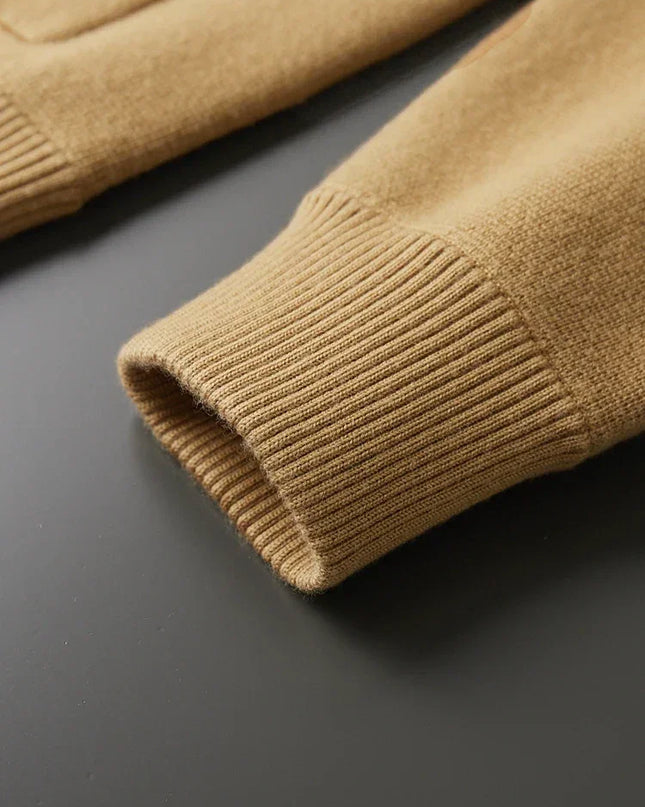 Close-up of a brown knitted sweater sleeve on a dark surface