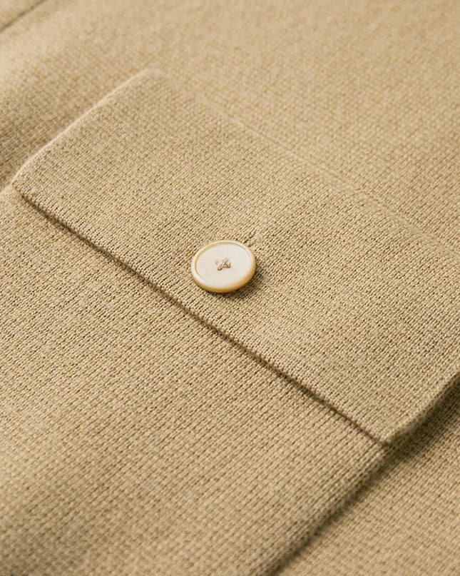 Close-up of a beige fabric with a button on a textured surface
