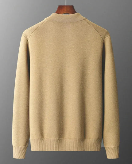 Beige sweater on a hanger against a gray background
