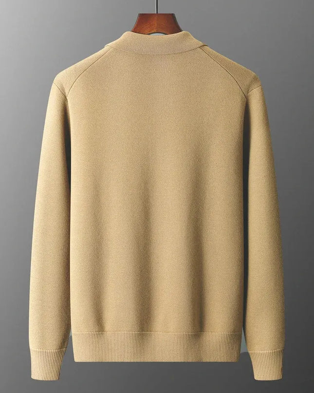 Beige sweater on a hanger against a gray background