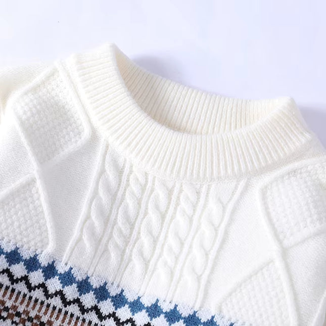 Close-up of a white sweater with blue and brown patterned hem on a white background