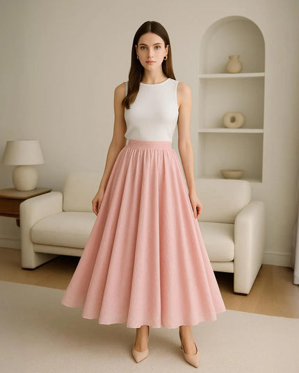 Woman wearing a white top and pink skirt in a living room setting