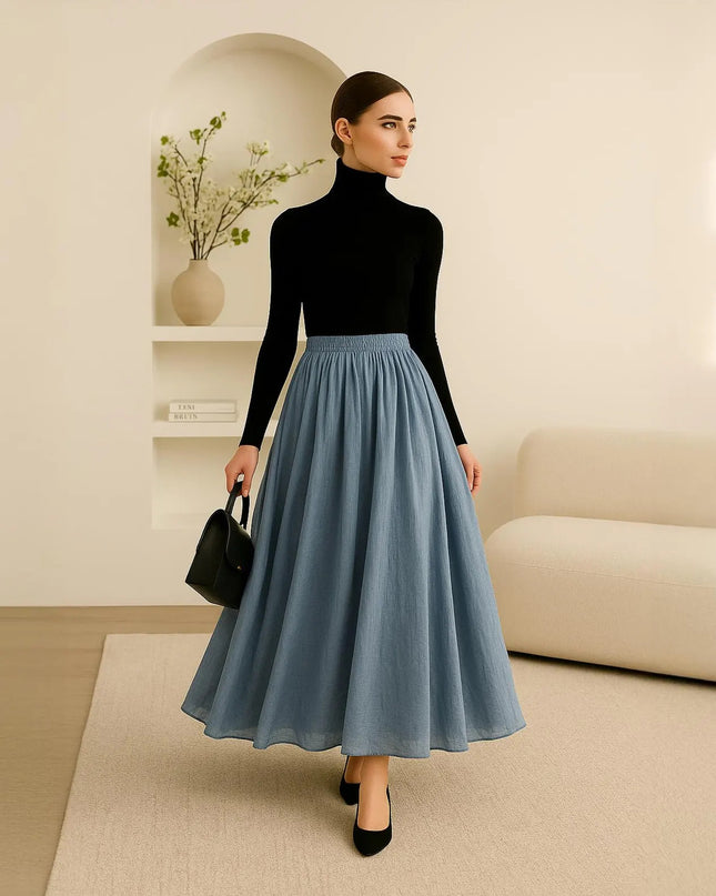 Woman wearing a black turtleneck and blue skirt in a modern living room.
