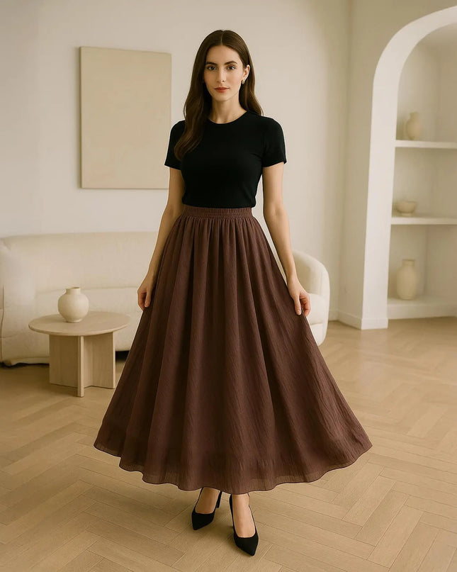 Woman wearing a black top and brown skirt in a modern living room.