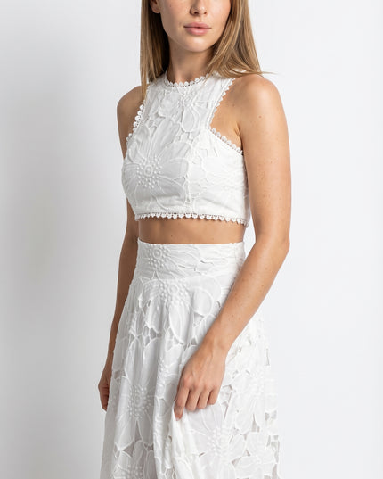 Woman wearing a white lace outfit on a white background