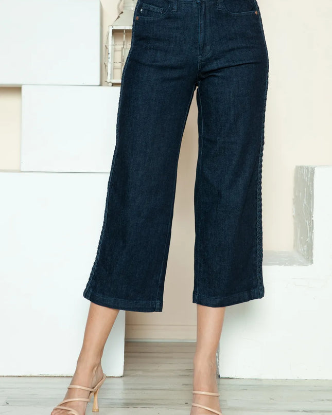 Person wearing dark blue wide-leg jeans in a minimal indoor setting