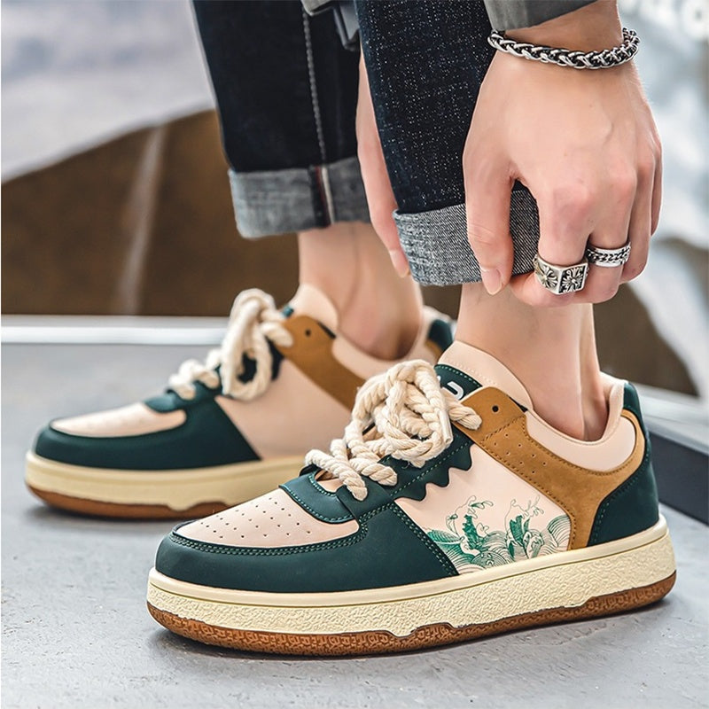 Person wearing a pair of green and brown sneakers with floral design on a concrete surface.