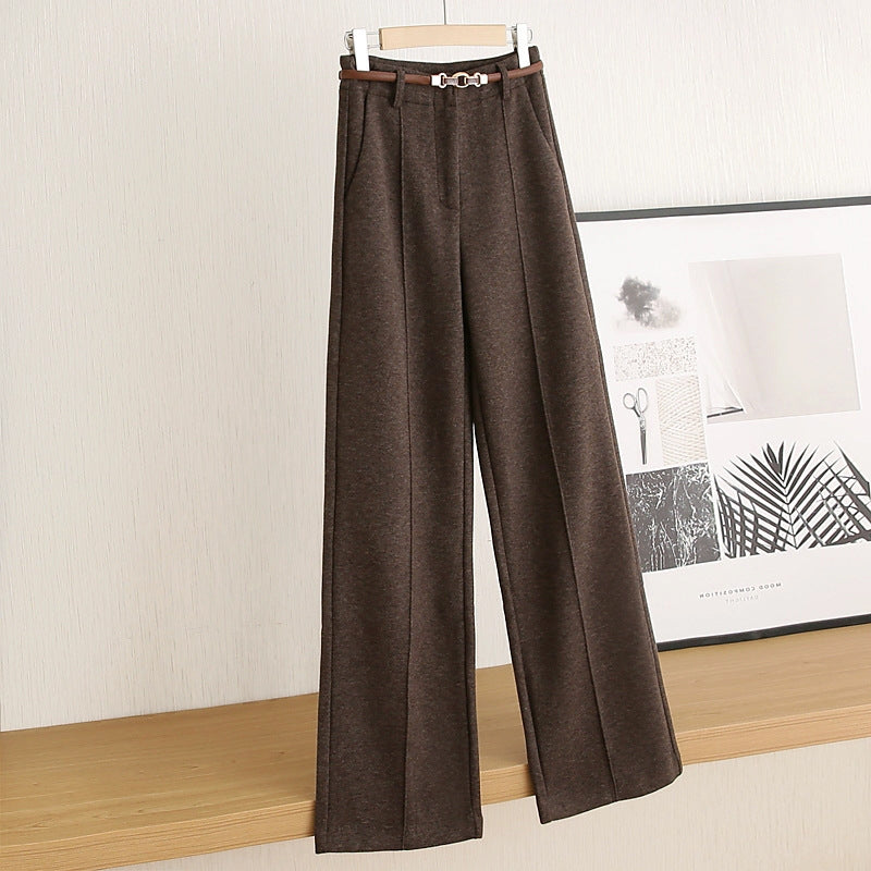 Brown wide-leg pants on a hanger against a neutral wall.