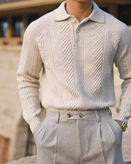 Person wearing a light gray knitted sweater and pants with a blurred background