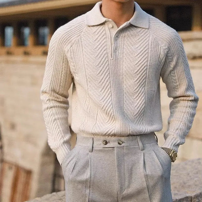 Person wearing a light gray knitted sweater and pants with a blurred background