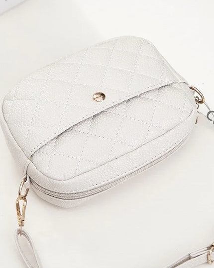 White glittery handbag with gold chain strap on a white background