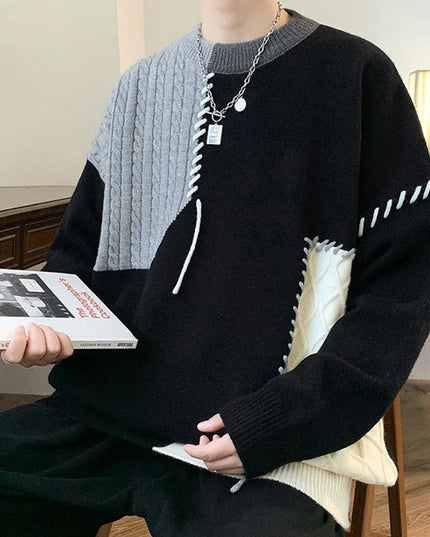 Person wearing a black and gray sweater holding a book in a room.