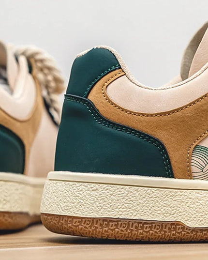 Close-up of a pair of green and brown sneakers with beige soles.