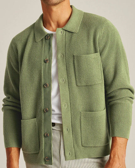 Green knitted cardigan worn by a person on a plain background