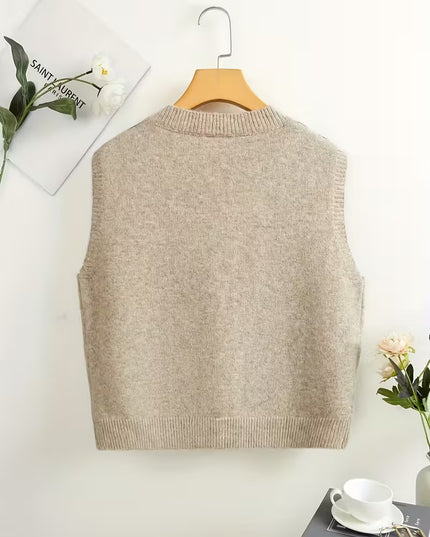 Beige sweater vest on a wooden hanger against a white background with decorative elements.